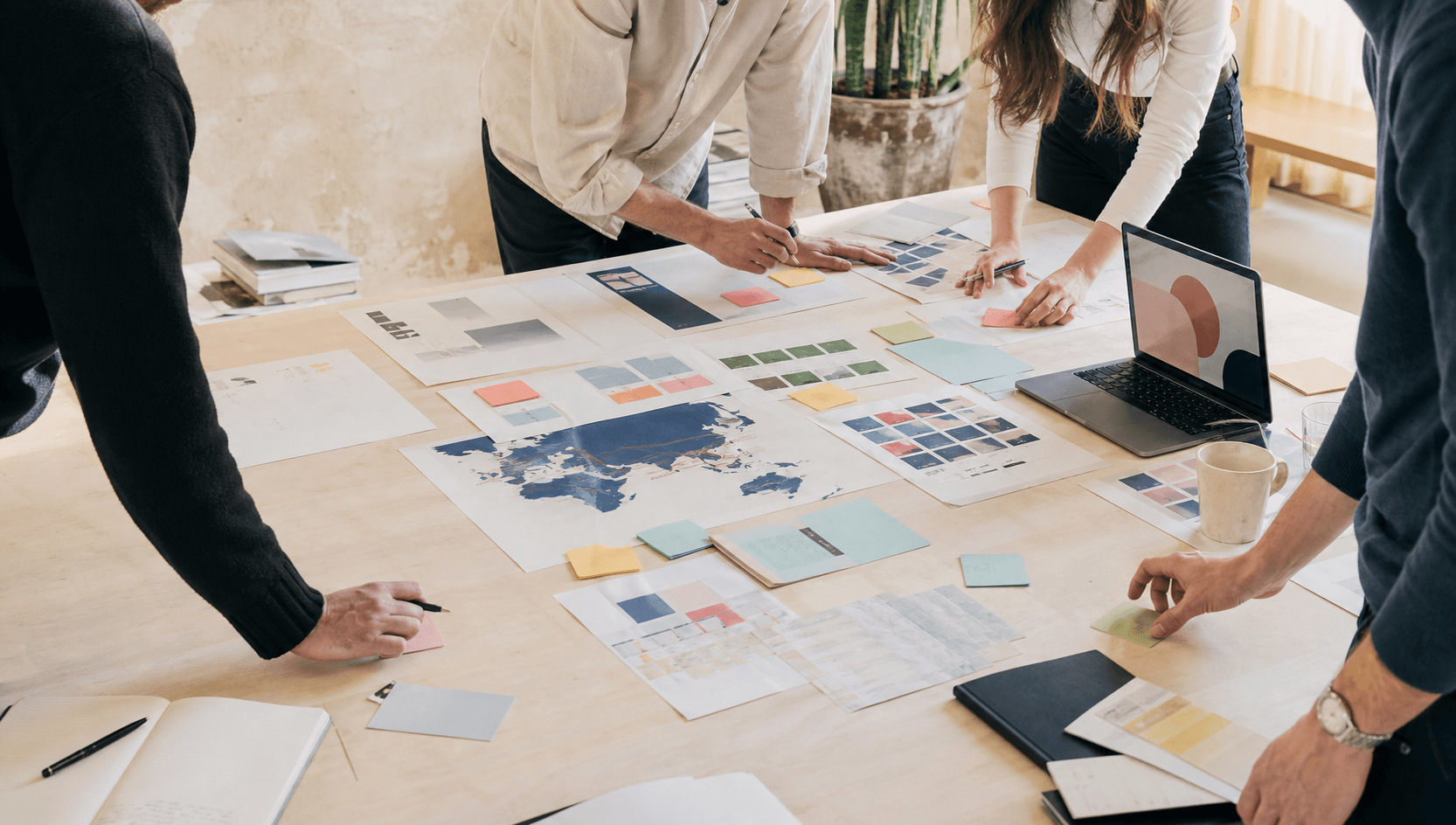 An overhead view of a strategy table covered in campaign materials, charts and prototypes
